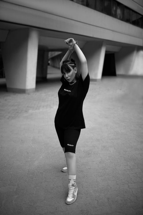 Free Stylish woman posing in a monochrome urban setting with an elegant stance. Stock Photo