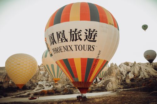 Free Spectacular hot air balloons soaring over Cappadocia's unique landscape at sunrise. Stock Photo