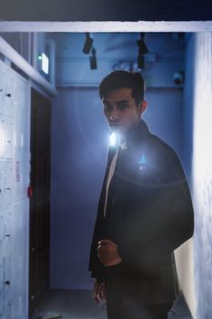 Photo by Koma Tang Mysterious portrait of a man with a serious expression in a dark hallway, creating a dramatic mood.