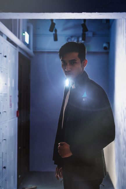 Photo by Koma Tang Mysterious portrait of a man with a serious expression in a dark hallway, creating a dramatic mood.