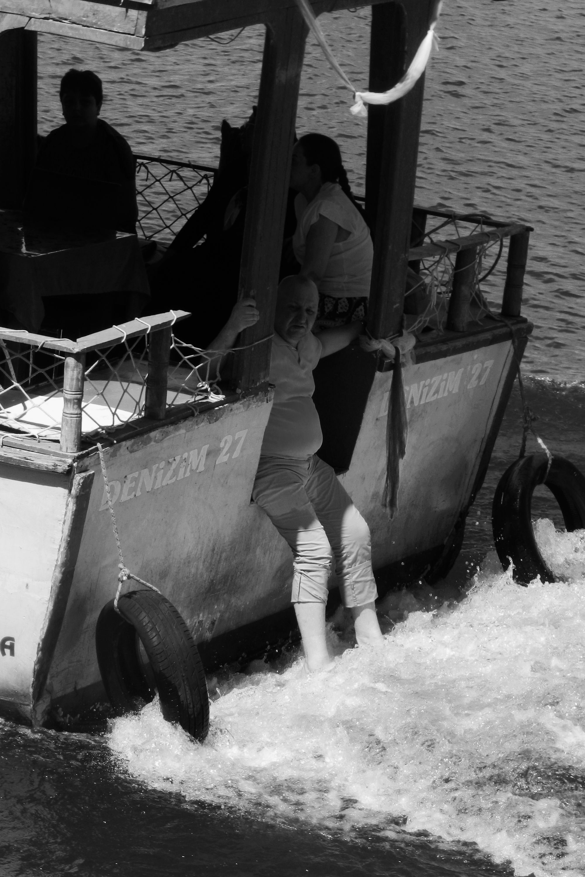 Black and white image of people enjoying a boat ride, displaying water trail.