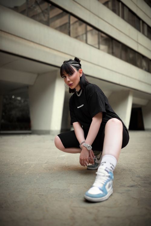 Free Model in stylish streetwear posing outdoors against an urban backdrop. Stock Photo