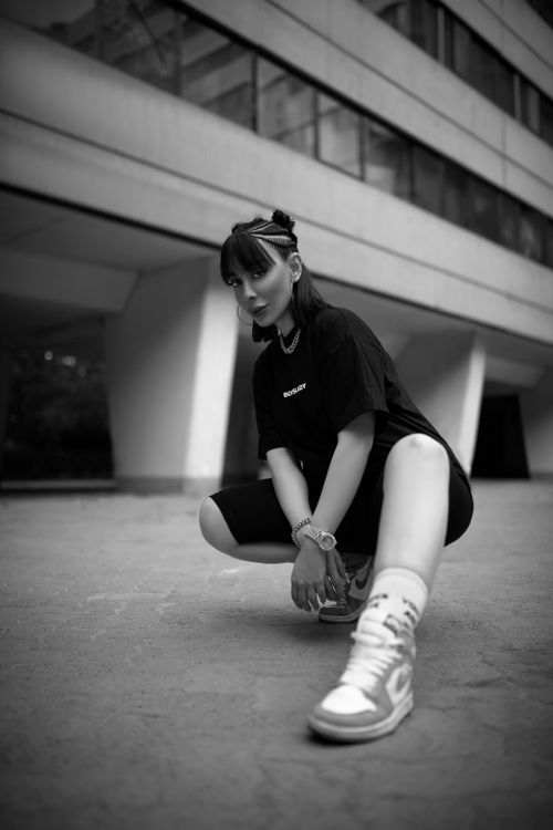 Free Black and white photo of a young woman posing confidently in streetwear. Stock Photo