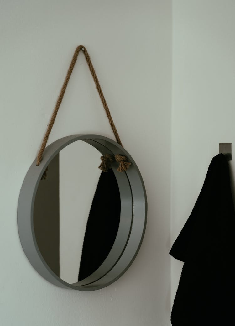 Round Mirror Hanging On String On Wall