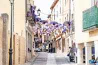 头顶悬挂着鲜艳的紫色雨伞，街景迷人