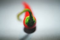 Selective Focus Photography of Red Chili on White Surface