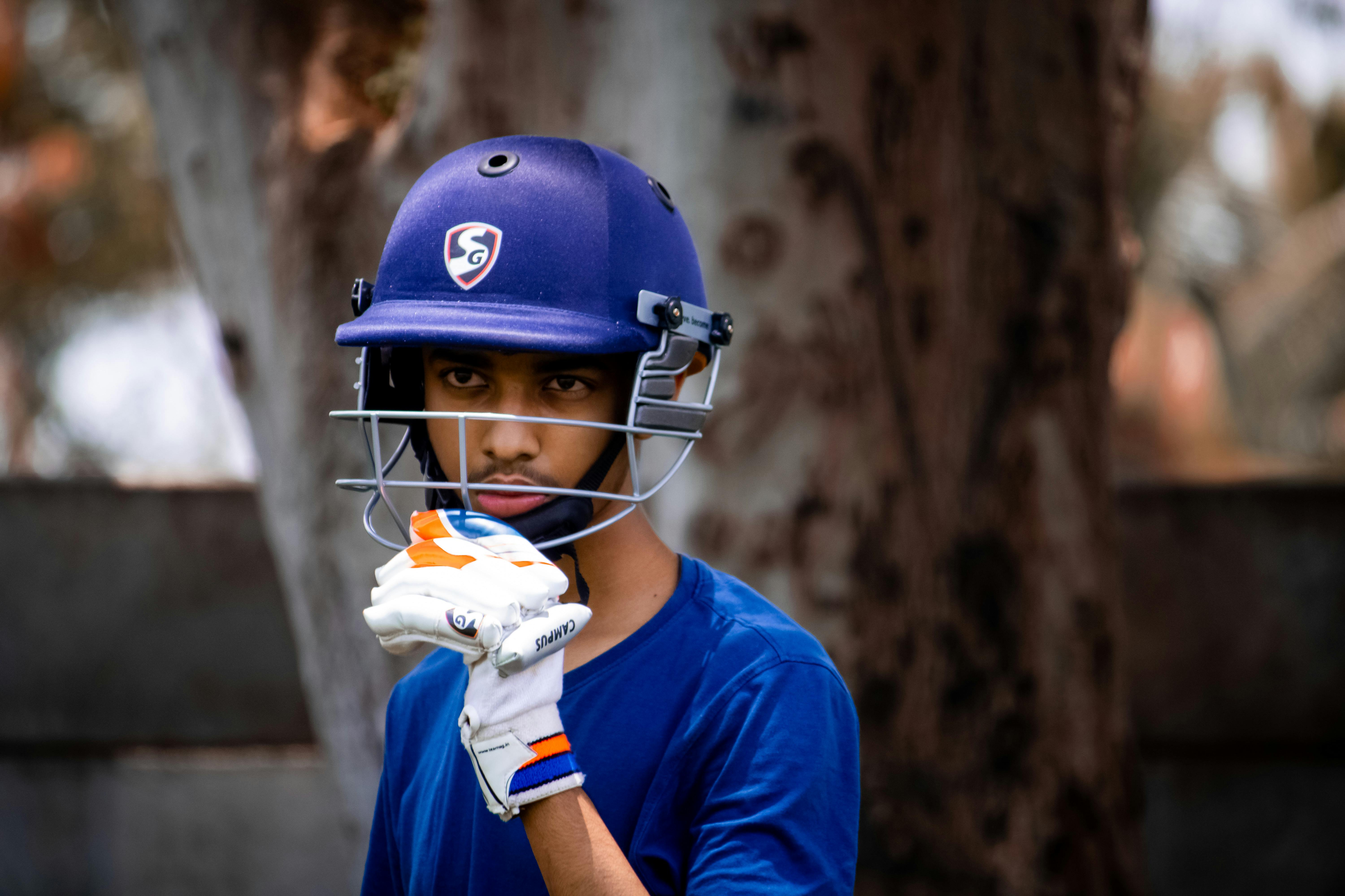 a boy wearing blue cricket helmet