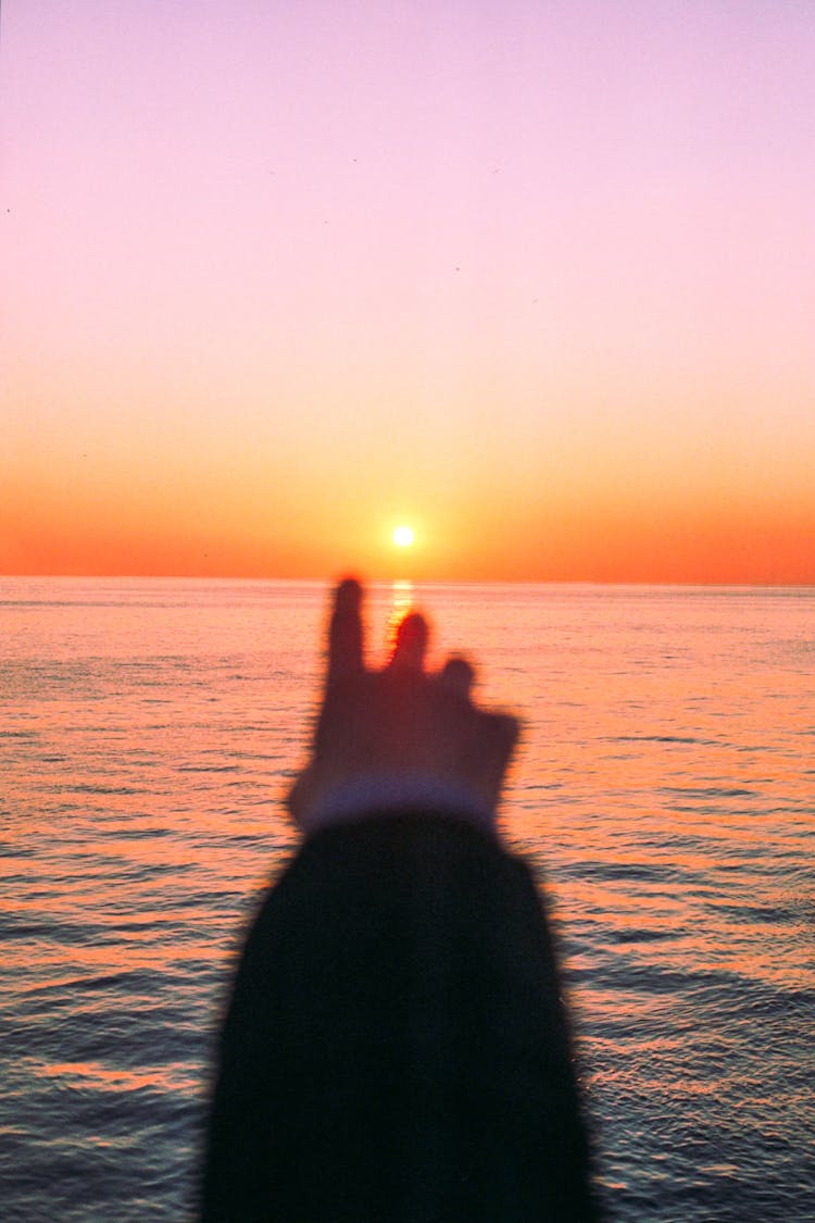 A Person's Hand Reaching The Sea