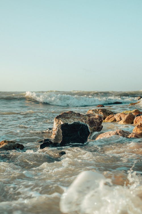 A Beach Waves Crashing on Rock Formations