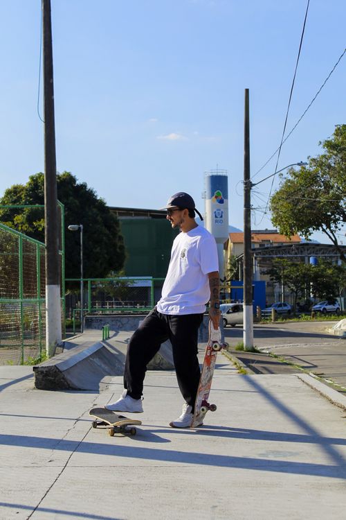 Free Skateboarder skillfully balancing on a skateboard in an urban park under a clear blue sky. Stock Photo
