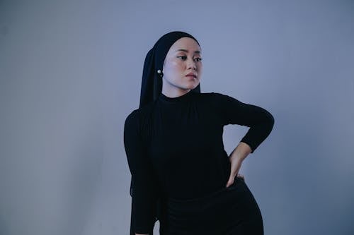 A Woman in Black Long Sleeves and Hijab with Her Hand on Her Waist