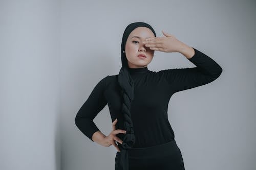 A Woman in Black Long Sleeves Covering Her One Eye