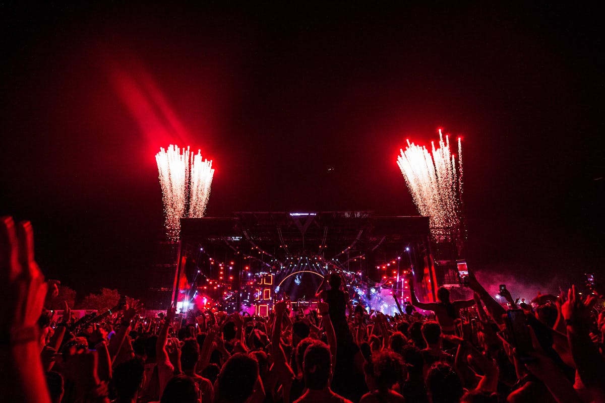 Wide shot of a stadium concert with stage lights and big crowd