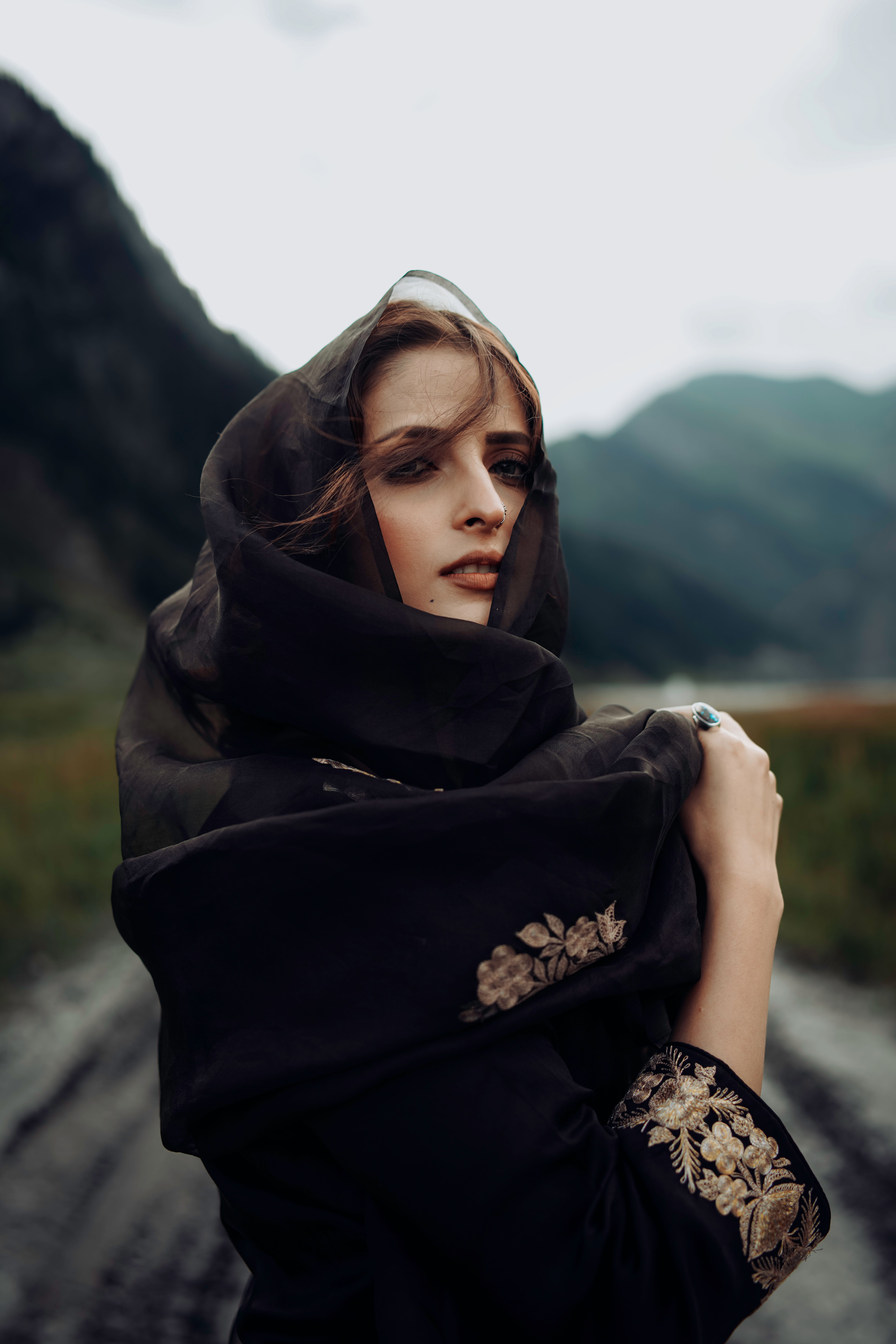 Portrait of a fashionable woman with a headscarf in Gurez's scenic mountain environment.