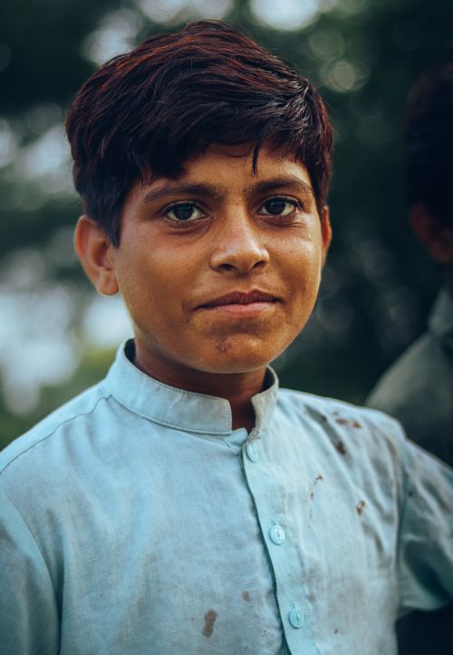 Free A confident teenage boy smiling outdoors in traditional attire. Stock Photo