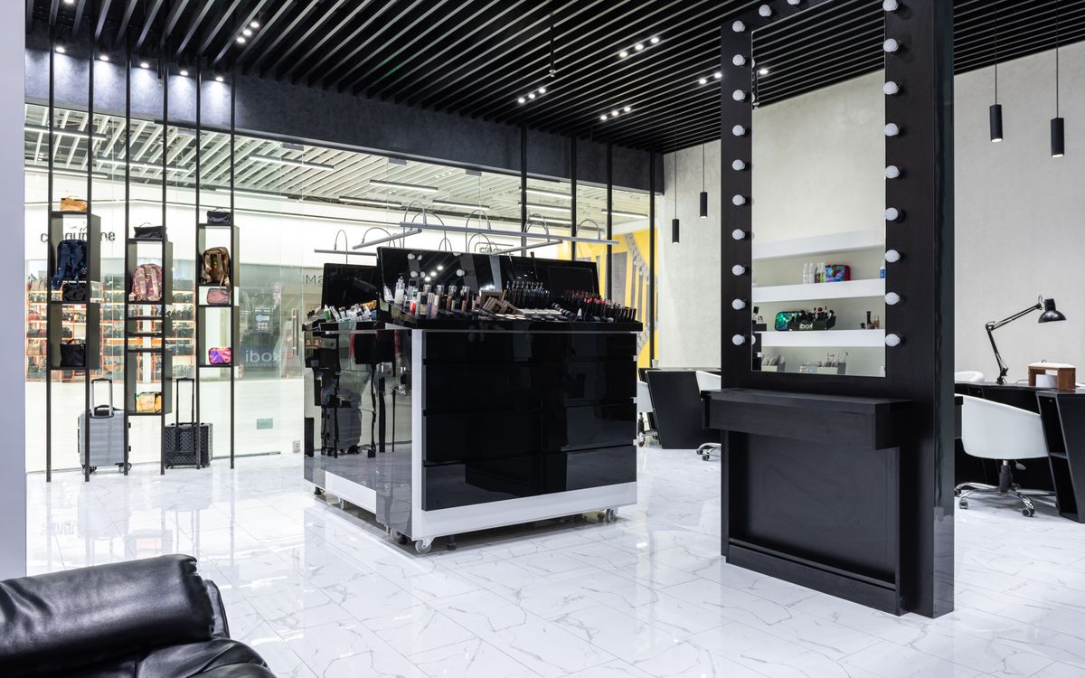 A sleek and modern salon with a central beauty product display and contemporary decor.
