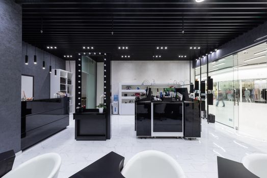 Spacious modern salon interior featuring sleek black and white decor with elegant lighting.