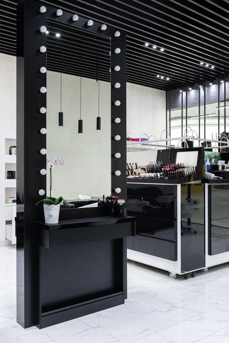 Mirror In Black Frame And Exposition Cabinet At Cosmetics Centre