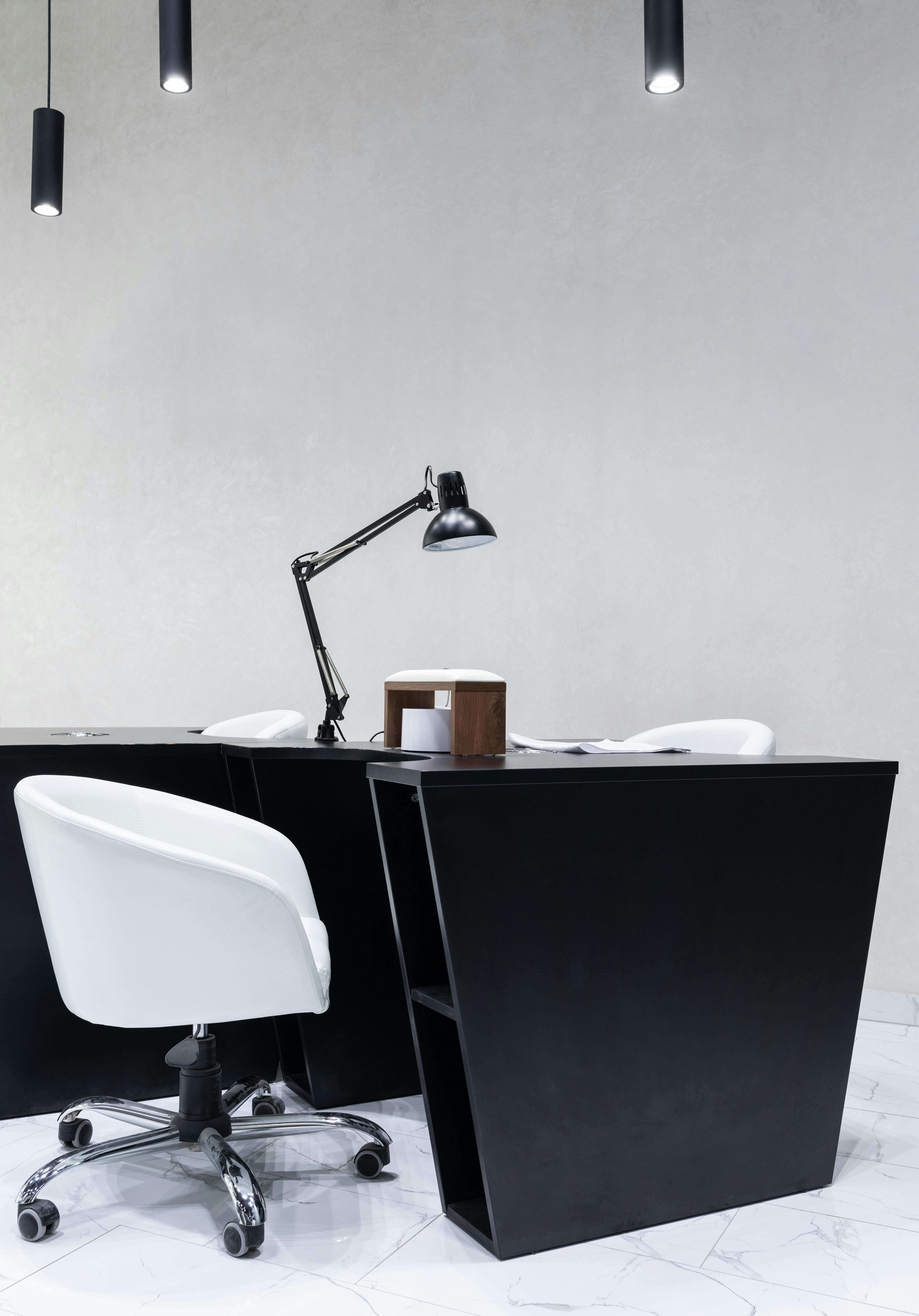 Sleek office interior featuring a black desk, white chair, and adjustable lamp.