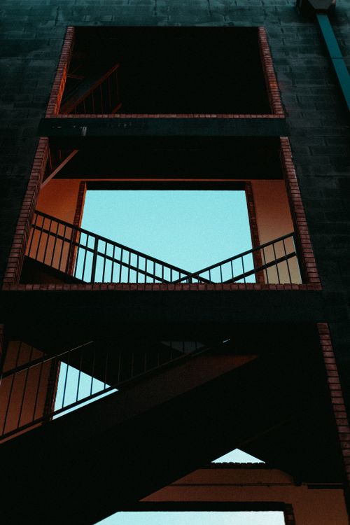 Free Moody stairwell silhouette with geometric patterns and vibrant contrasts. Stock Photo