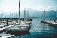 一个宁静的码头在意大利特色停靠帆船对山区背景下明亮的天空