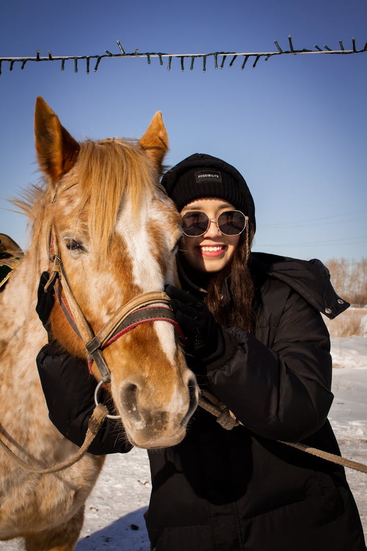 A Smiling Woman Holding A Horse