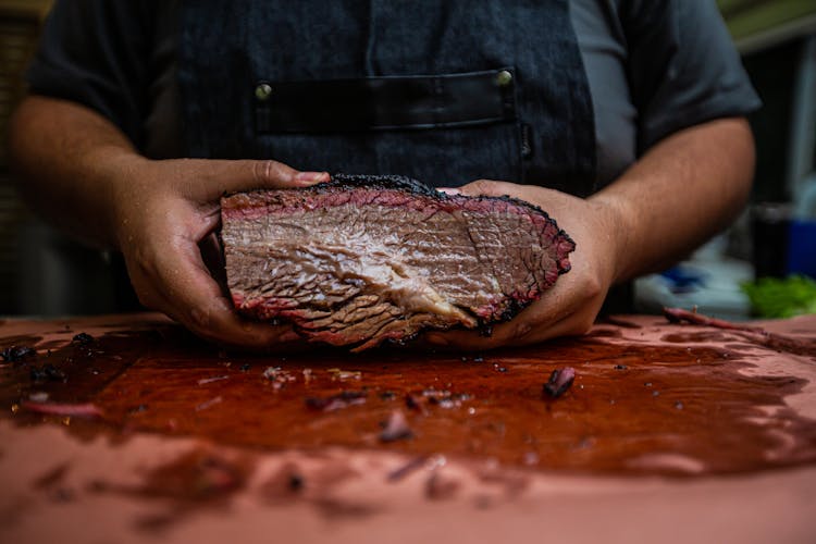 Close-up Of Butcher Holding Meat In Hands