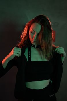 Creative portrait of a young woman in moody neon lighting, capturing a modern and stylish look.