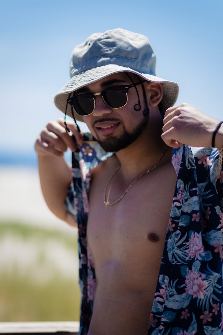 Young Bearded Man In Sunglasses Wearing Floral Shirt And Hat