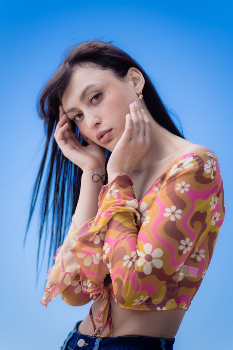Young Woman Posing In Blue Studio Background