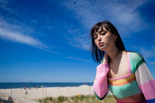 A Woman in Colorful Knitted Sweater Looking with Her Hand on Her Neck