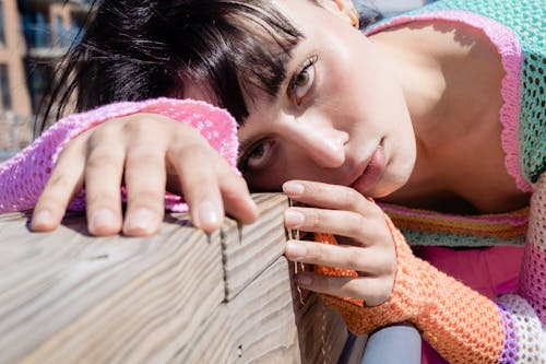 A Woman in Knitted Sweater Lying on Brown Wooden Surface