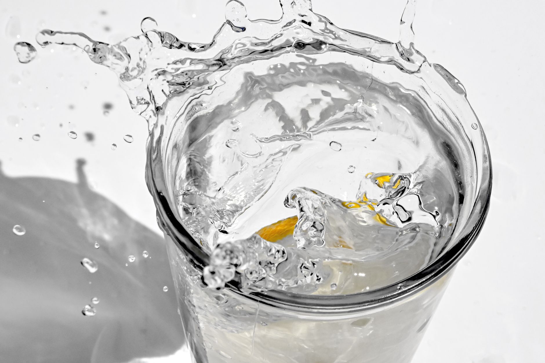 Dynamic close-up of a lemon water splash, showcasing vibrant movement against a white background.
