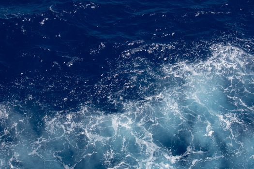 A stunning aerial view of vibrant ocean waves and seafoam, perfect for backgrounds.