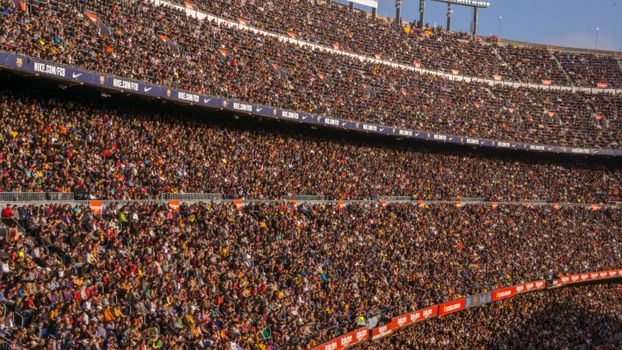 A vibrant crowd fills Camp Nou stadium, Barcelona during a football match.