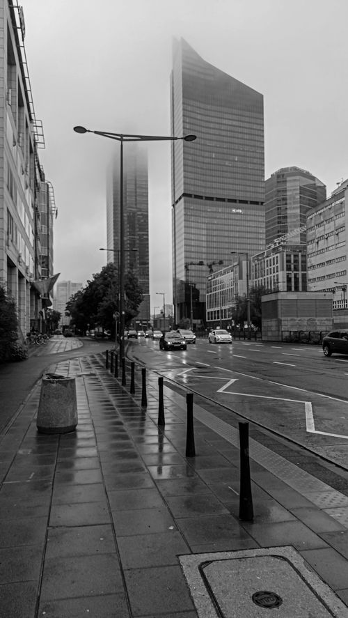 Free Black and white image of modern skyscrapers in Warsaw's city center on a rainy day, showcasing urban life and architecture. Stock Photo