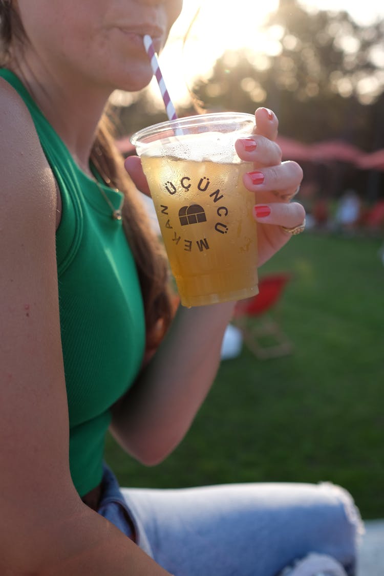 Close Up Photo Of Woman Drinking From A Straw