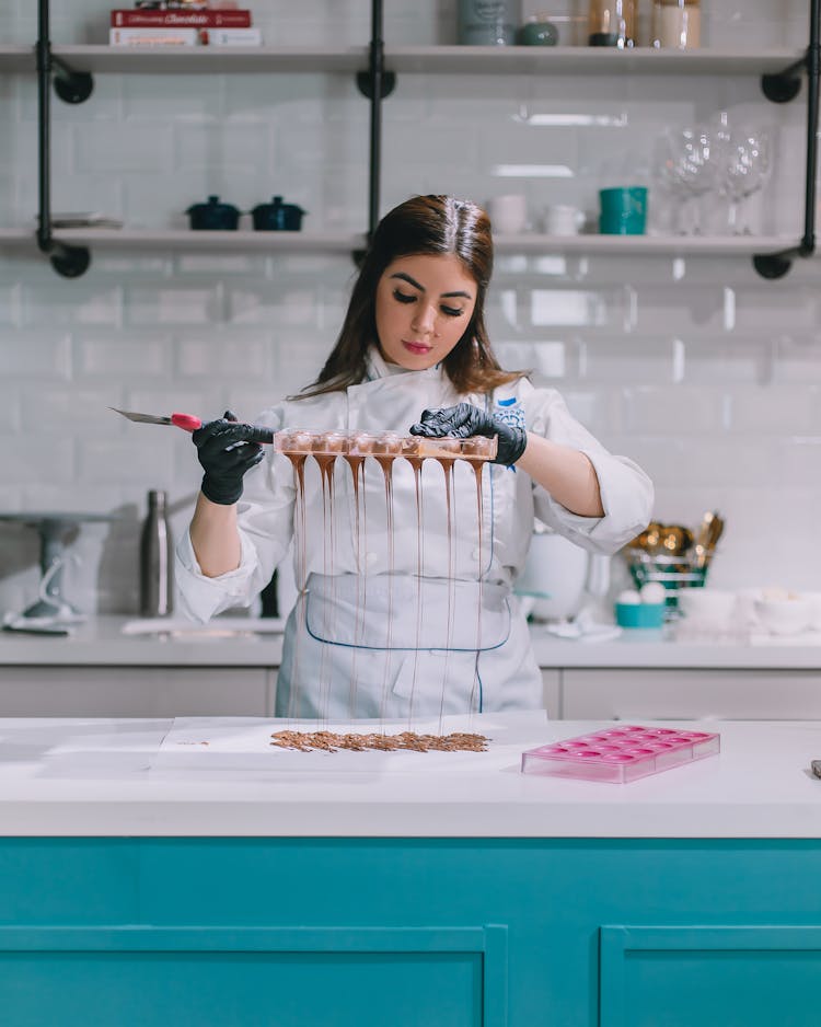 Woman Pouring Chocolate On Cakes