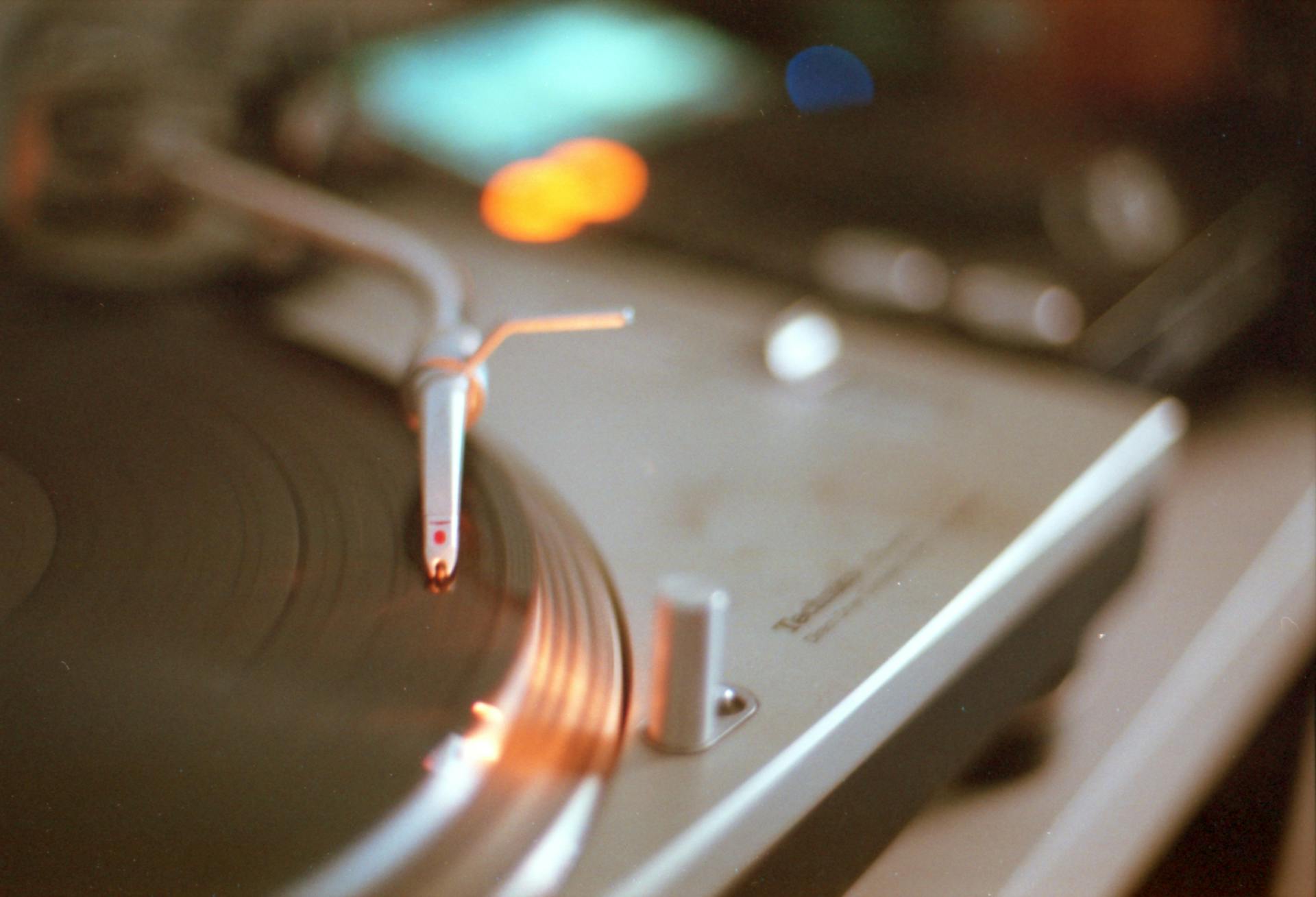 A beautifully captured vintage turntable playing a vinyl record with bokeh light effects.