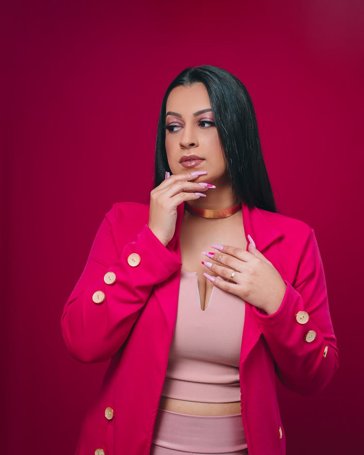 Woman In Pink Blazer With Hand On Chin 