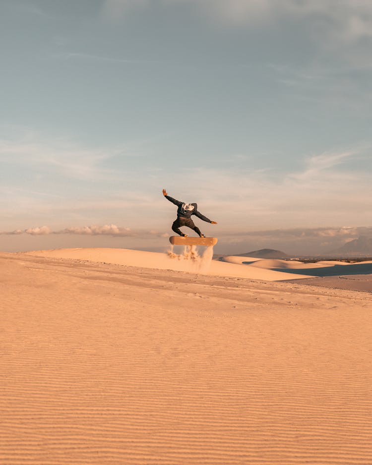 Skateboarder Jumping On Dune