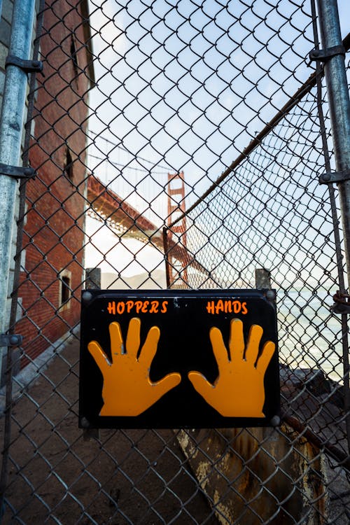 Sing Hoppers Hand Hanging on a Fence