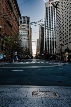 Dramatic cityscape of empty street flanked by skyscrapers in San Francisco.