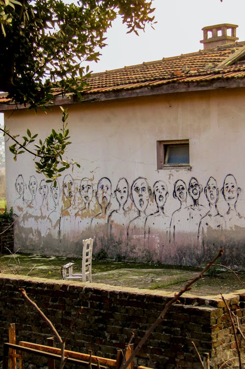 Painting of People on White Wall of a House 