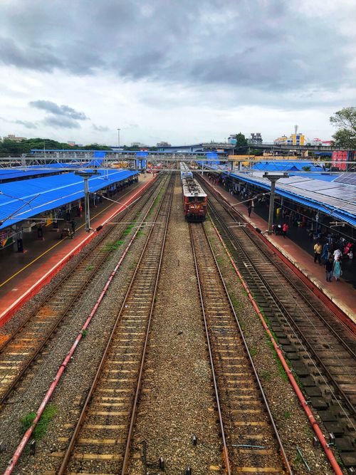 Free Aerial view of a busy railway platform in Kochi, India, with a train and commuters. Stock Photo