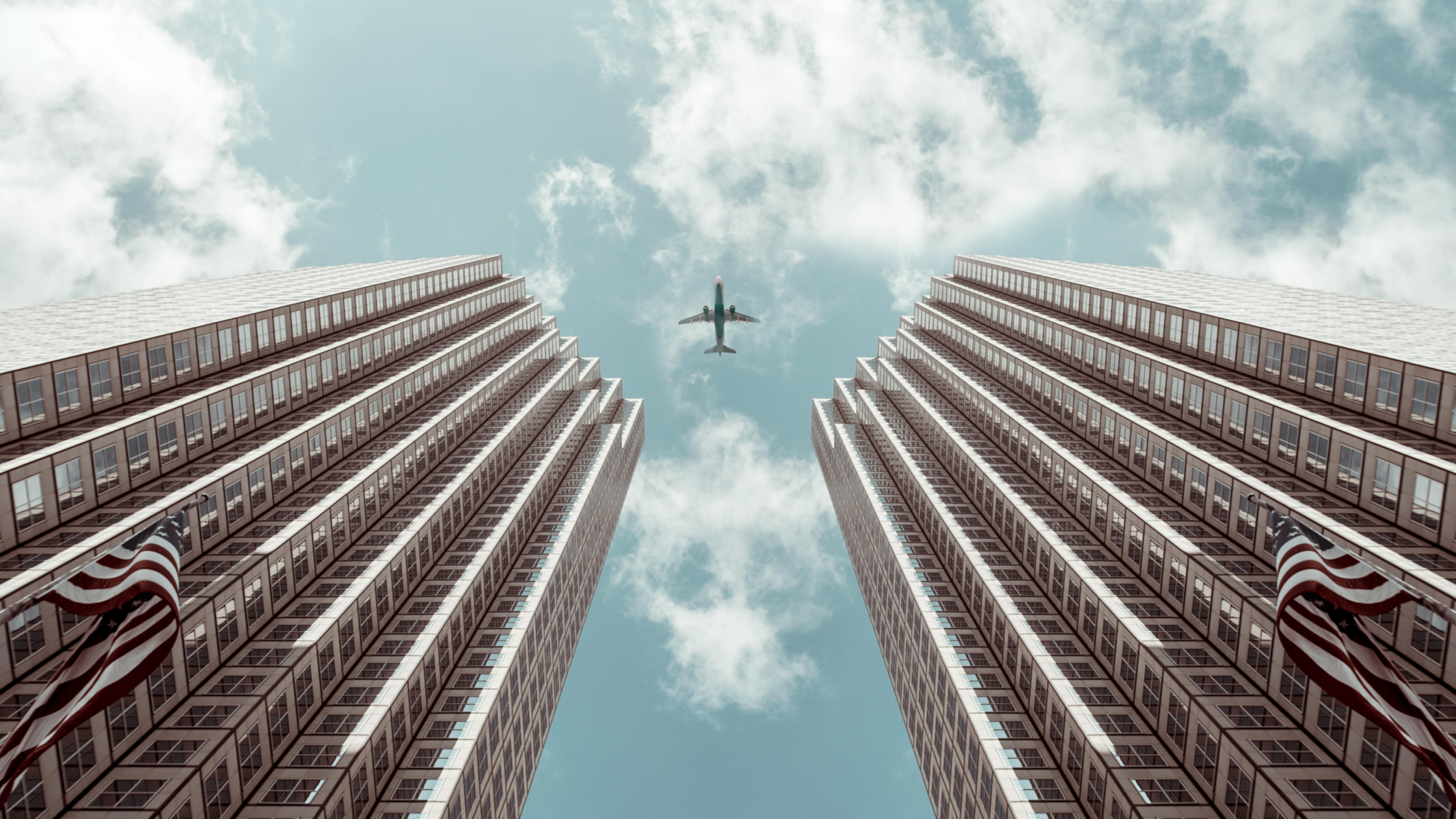Worm's-eye view Photo of Plane Between Two High-rise Buildings · Free Stock  Photo