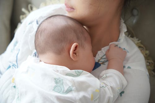 Free A Newborn Baby Lying on Her Mother's Chest Stock Photo