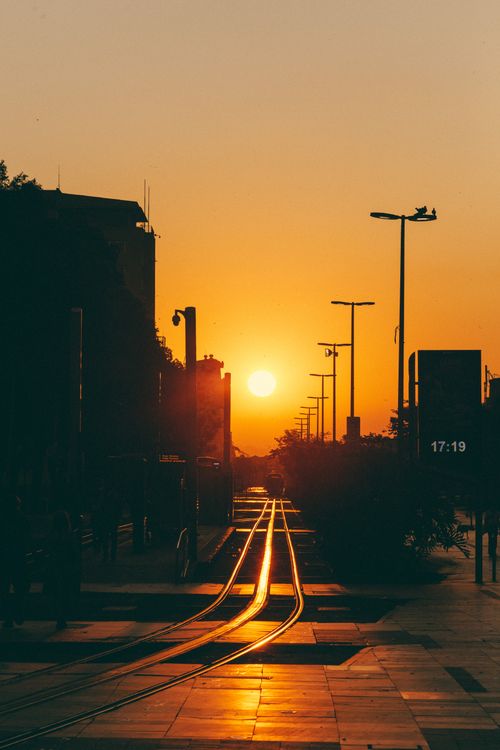 Free Silhouette of the Rio tramway at sunset with glowing golden skies, capturing a street scene in vibrant Rio de Janeiro. Stock Photo