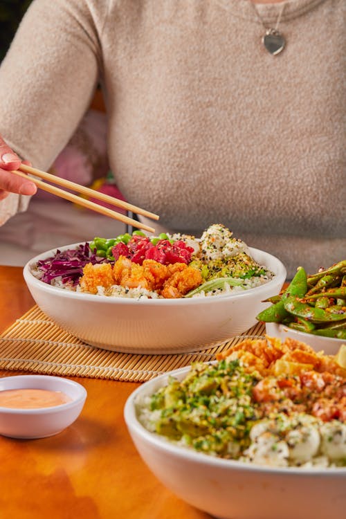 Close-up of People Eating Asian Food in Bowls