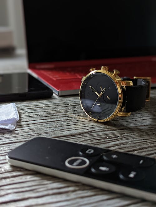 Black Analog Wristwatch Beside Laptop and Smartphone